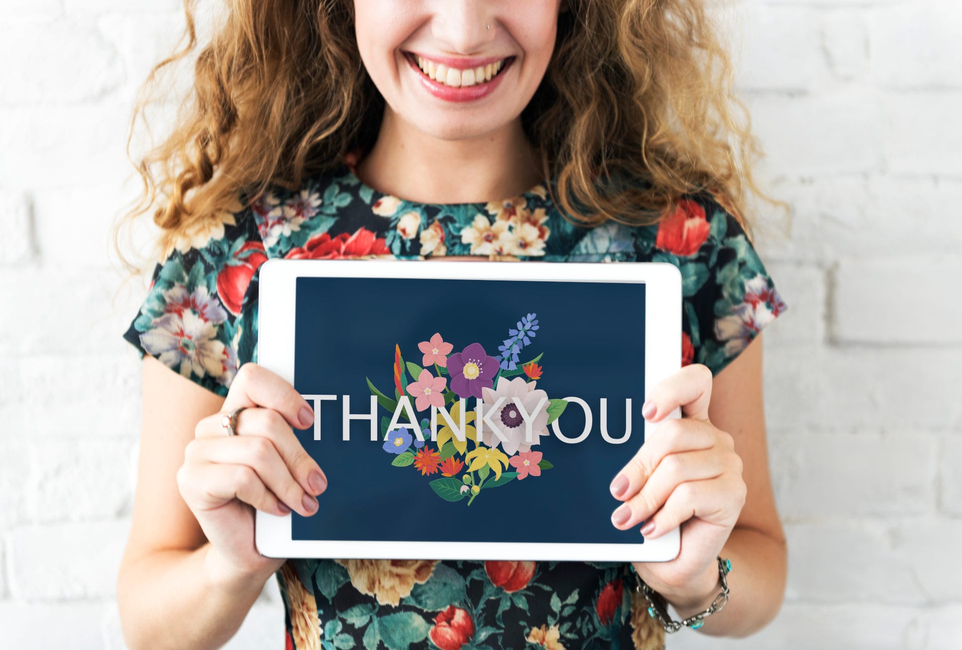 woman holding thank you on tablet